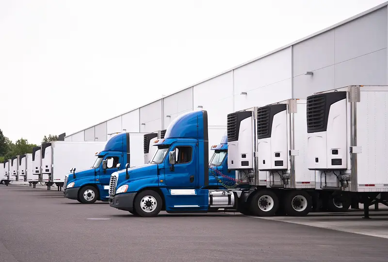 99image_quad (2)-1 Blue trucks parked at a loading dock.