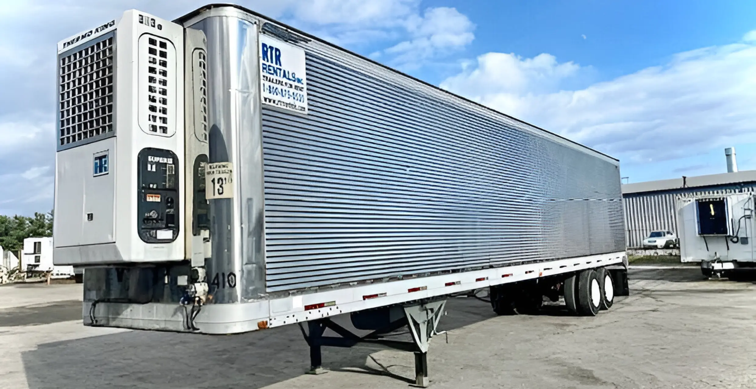 Silver refrigerated trailer parked in a lot.